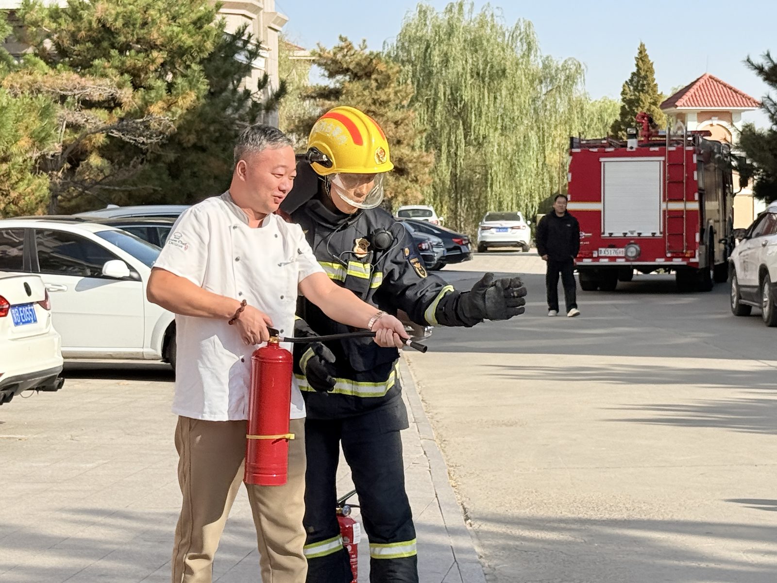 工作人员在消防战士指导下进行灭火实操